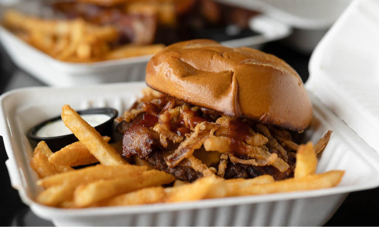 The NW Barbecue: smash burger topped with thick-cut bacon, cheddar, crispy onions, and Huckleberry BBQ sauce, served with fries.